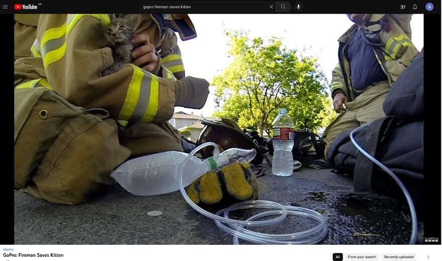 Still from a Go-Pro advertisement showing firemen rescuing a kitten