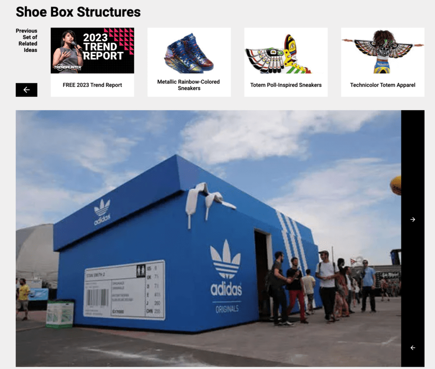 People walk out of a popup shop that looks like a large blue Adidas shoe box
