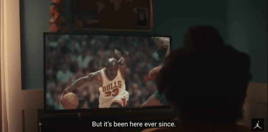 Someone watches footage of Jordan playing basketball on TV in a dark room