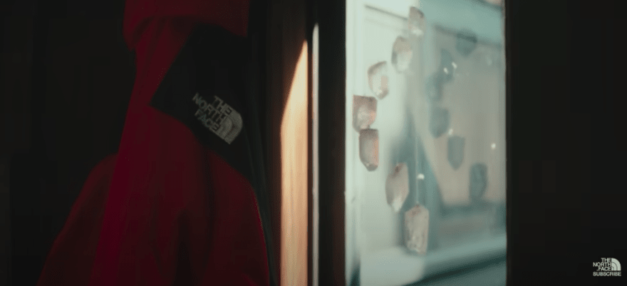 Still from a North Face video showing a red North Face jacket hanging up with the brand logo on display
